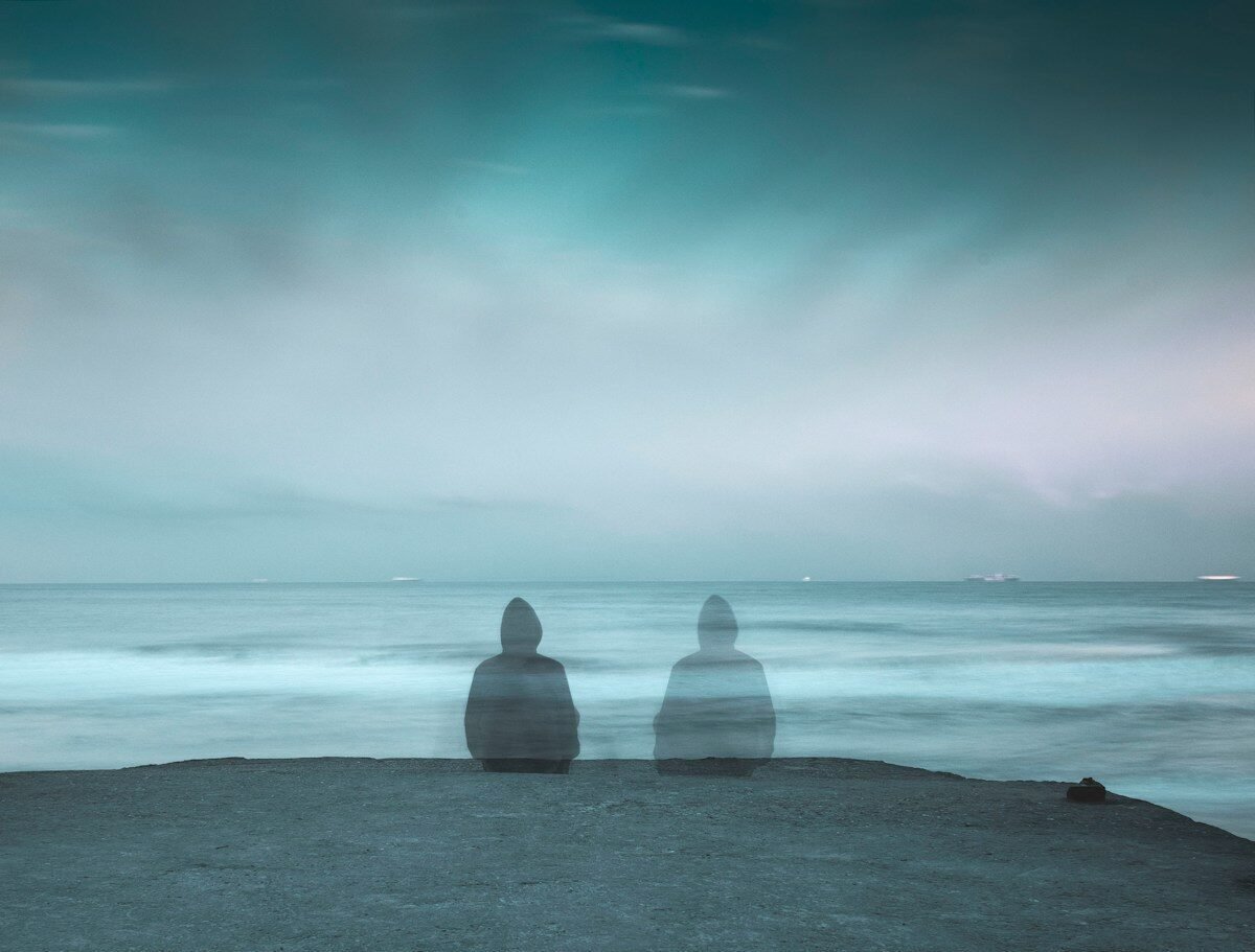 3 white and gray stone on black sand near body of water during daytime