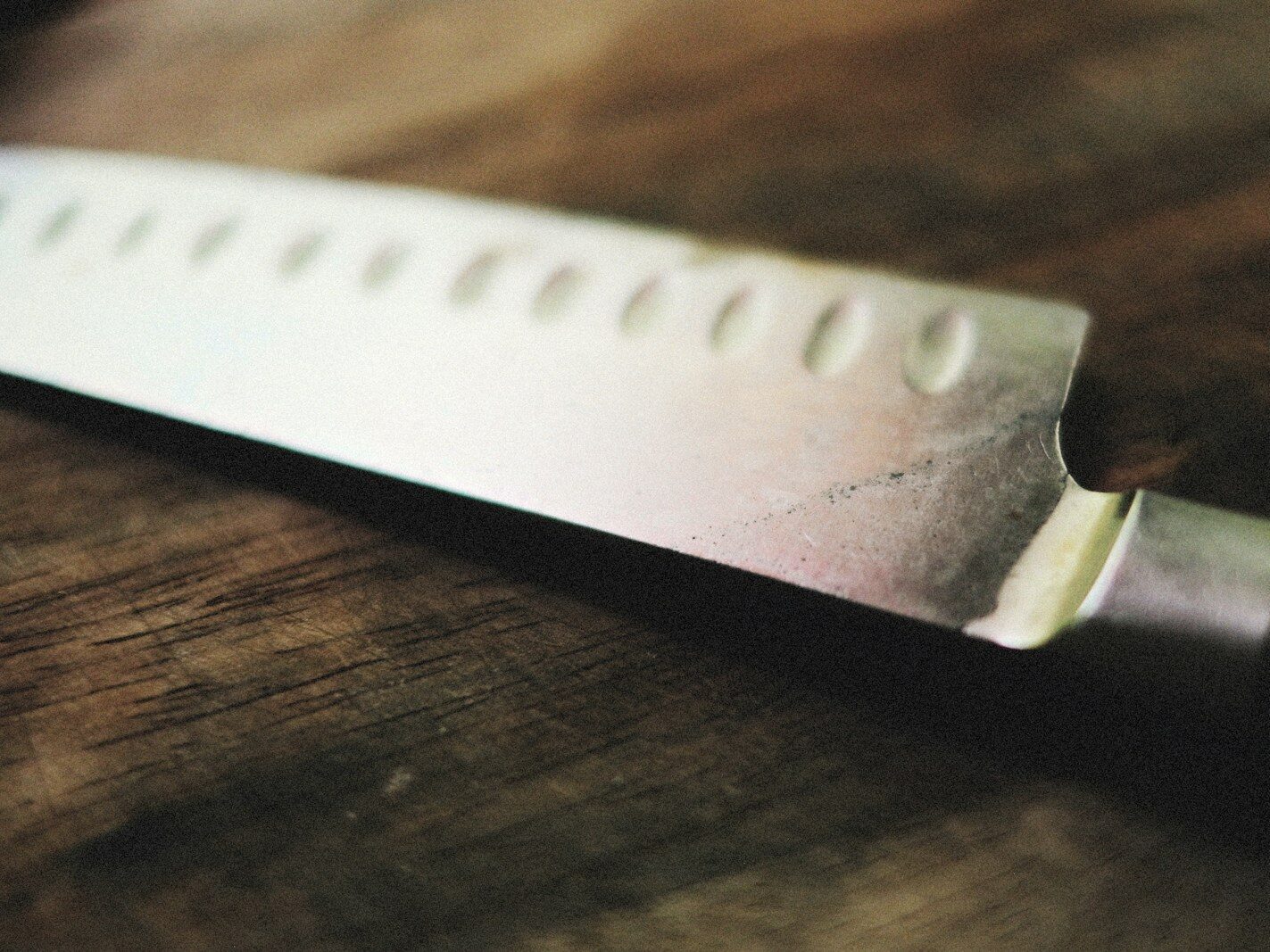 a close up of a knife on a wooden table